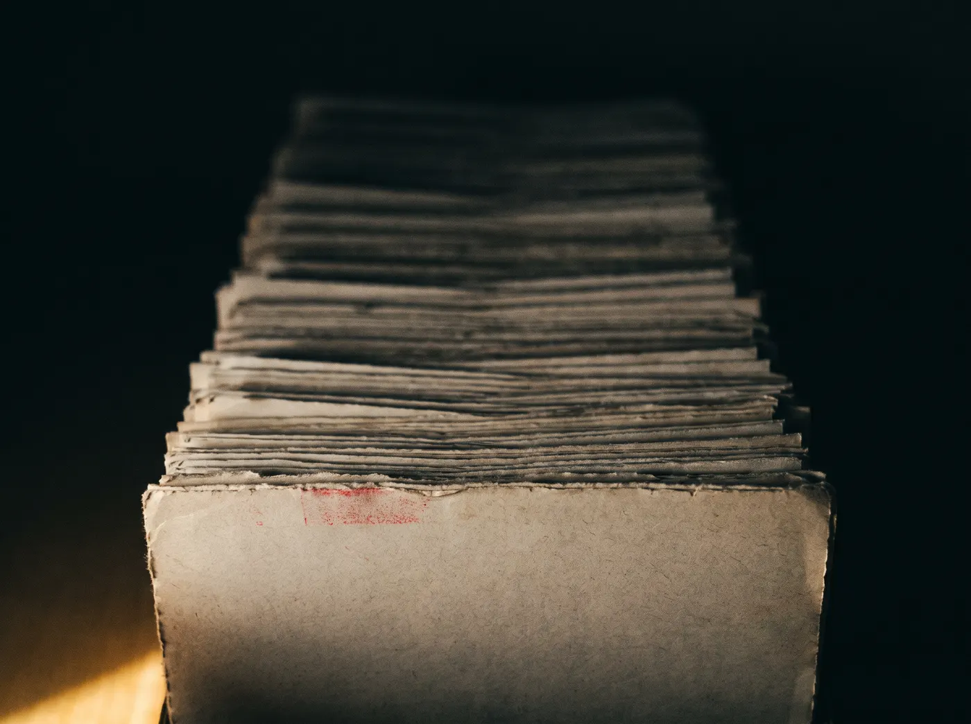 A tall stack of newsprint receding into darkness